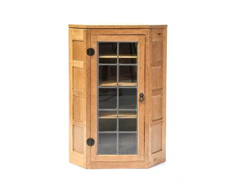 Workshop of Robert Mouseman Thompson (Kilburn): An English Oak Panelled Hanging Corner Cupboard, the leaded glazed door enclo