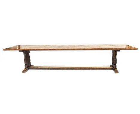 Robert Mouseman Thompson (1876-1955): An English Oak 12ft Refectory Table, the adzed dowelled top, on two shaped supports joi