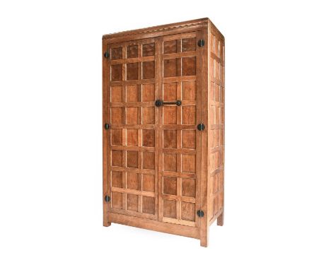 Robert Mouseman Thompson (1876-1955): An English Oak Panelled Double Wardrobe, 1930s, with half penny moulding, wrought iron 