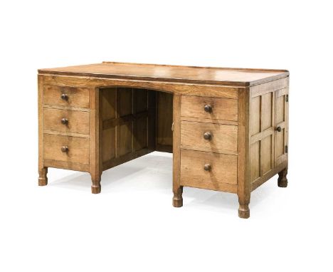 Robert Mouseman Thompson (1876-1955): An English Oak Panelled Kneehole Desk, 1930s, with upstand, the adzed rectangular top a