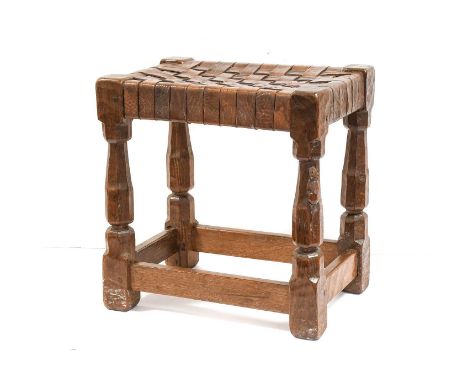 Robert Mouseman Thompson (1876-1955): An English Oak Stool, 1930s, strap leather top, on four octagonal legs joined by stretc