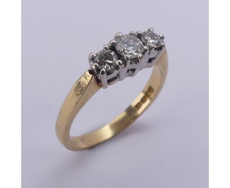 A three stone diamond Ring, the brilliant cut stones claw set in 18ct yellow and white gold, approx. total diamond weight 0.4