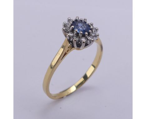 A sapphire and diamond cluster Ring, the oval cluster 9.5mm long, all mounted in 18ct yellow and white gold, Size P½, 3.1g. 