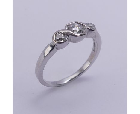 A three stone diamond Ring, the centre stone approx. 0.25ct with a smaller stone on either side, all mounted in 18ct white go