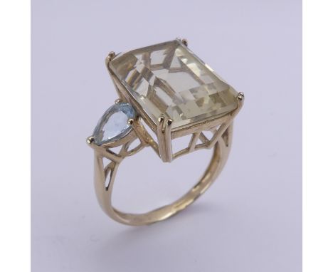A QVC citrine Dress Ring, the emerald cut stone 15.8mm x 11.9mm with a pear shaped pale blue stone on either side, all claw s