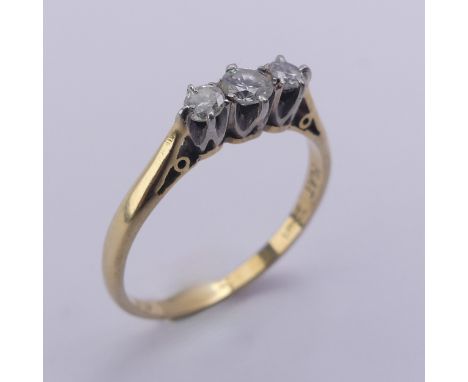 A small three stone diamond Ring, approx. total diamond weight 0.24ct, mounted in 18ct yellow gold and platinum, Size M, 2g. 