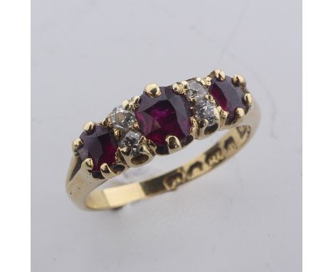 A ruby and diamond Ring, the three graduated rubies with two small diamonds vertically set between each, all mounted in 18ct 