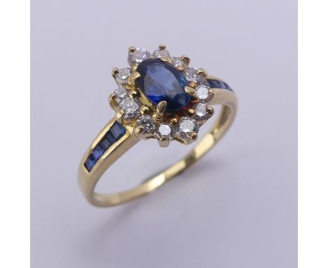 A sapphire and diamond cluster Ring, the central oval facetted sapphire approx. 5.9mm long, within a surround of small brilli