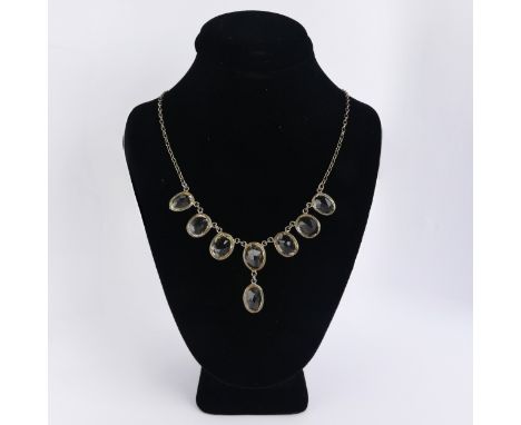 A vintage citrine Necklace, the seven oval facetted stone with one further suspended below collet set on an integral silver t