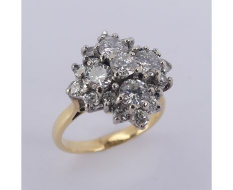 A diamond cluster Dress Ring, the largest four stones each approx. 0.3ct around a smaller central stone and with a surround o
