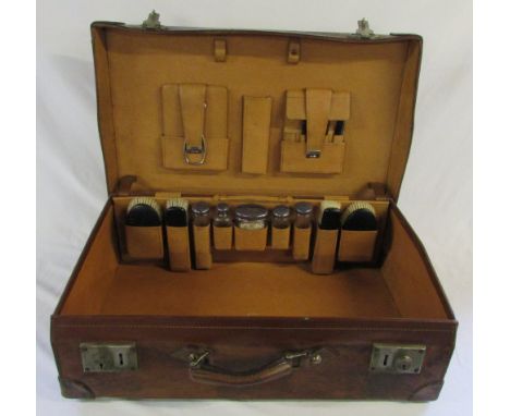 Vintage leather suitcase with accessories inc silver topped bottles London 1904, mirror and brushes L 64 cm