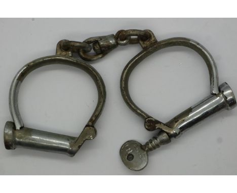 Hiatt pair of UK police issue handcuffs, numbered 110, with key. P&amp;P Group 1 (£14+VAT for the first lot and £1+VAT for su