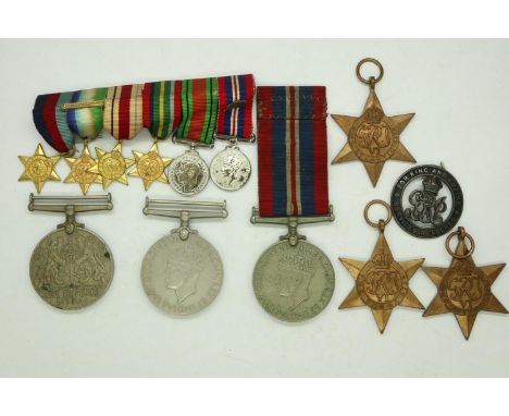 Two WWII war medals and a defence medal with three WII stars, a miniature set of WWII medals and a damaged silver WWI wound b