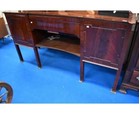 A late 19th or early 20th Century mahogany sideboard having central drawer and shelf, flanked by cupboards, raised on square 