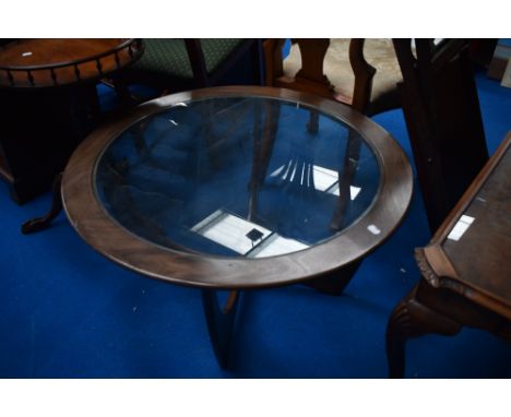 A vintage teak G plan style circular coffee table having drop in glass top