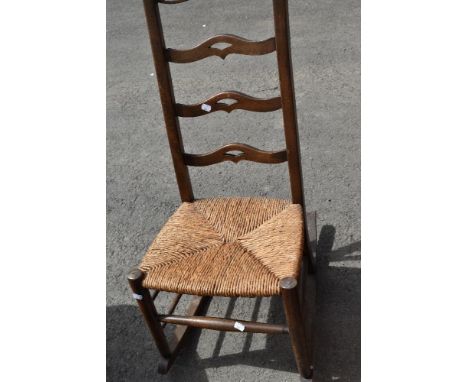 A traditional rush seated ladder back rocking chair