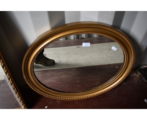 A vintage gilt frame oval wall mirror