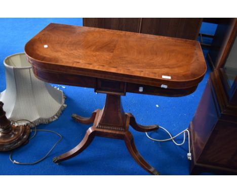 A reproduction Regency yew wood fold over card table having quatrefoil base