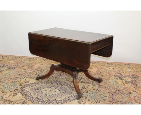 Regency mahogany Pembroke table with end drawers, on shaped pedestal support and four carved splayed legs with brass-capped c