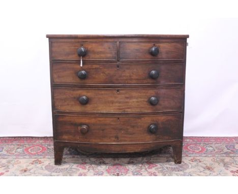 George IV mahogany bow front chest of two short and three long graduated drawers with ebonised bun handles, on bracket feet