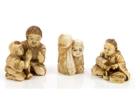 Two late 19th century Japanese carved ivory netsukes of a figure pouring water from a bucket, two children playing and anothe