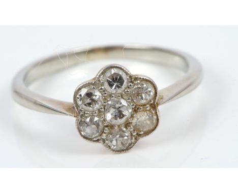 Diamond cluster ring with a flower-head cluster of seven old cut diamonds, on precious white metal shank.  Ring size K½