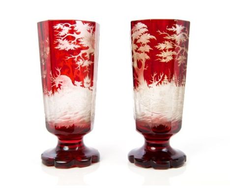 Pair of mid-19th century Bohemian ruby overlaid faceted glass pedestal vases, each deeply etched with hunting scenes with sta