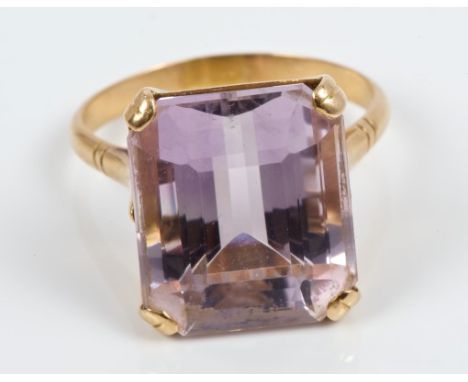 Amethyst single stone ring with a large rectangular step cut amethyst measuring approximately 16.45mm x 14.00mm, in yellow me