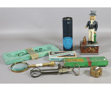 A cast iron Uncle Sam money box, mother of pearl set brass magnifying glass, brass compass and vintage rolls razor set, along