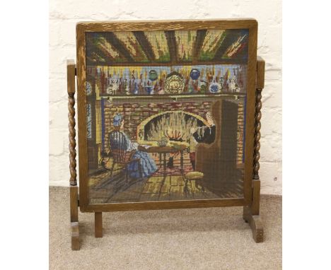 An oak metamorphic firescreen/occasional table with woolwork panel and barleytwist supports.