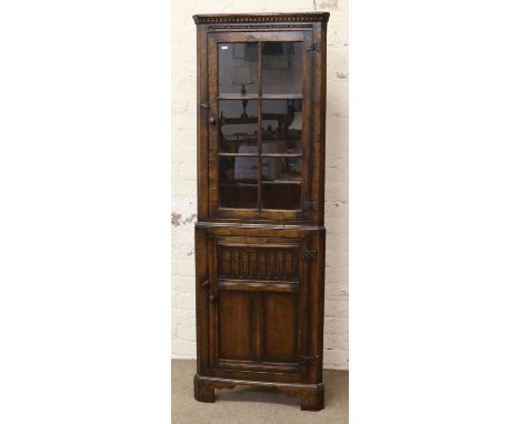 A good quality carved oak corner display cupboard over cupboard base raised on bracket feet.