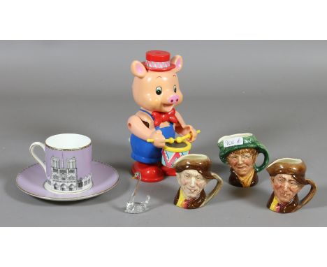 Three miniature Royal Doulton character jugs along with a Wedgwood Grand Tour cup and saucer and a clockwork pig playing a dr
