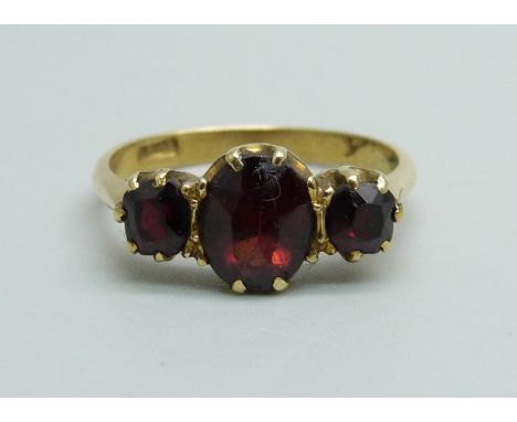 An 18ct gold three stone garnet ring, 3.6g, P 