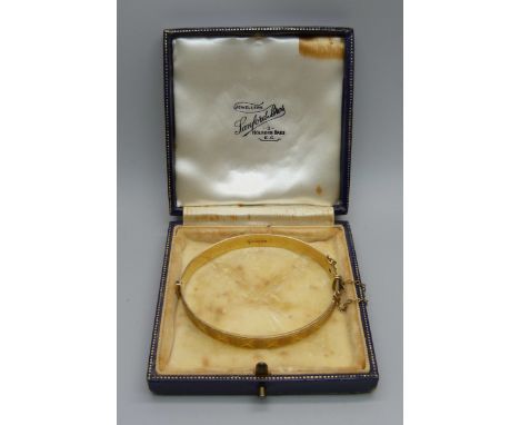 A 9ct gold bangle with engraved decoration, Fred Manshaw, 15.4g 