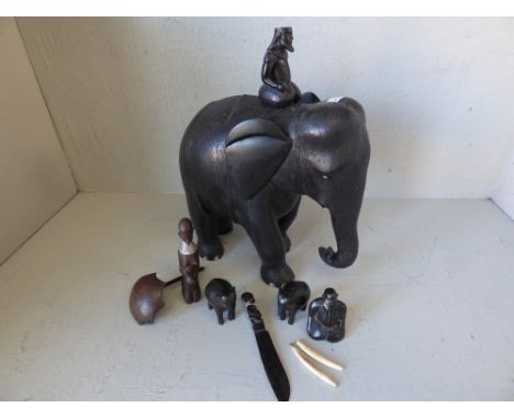 Carved black elephant with inlaid ivory style toes & tusk; other carved elephants & tribal figures (vendors cousins father br