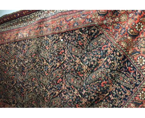 LATE 19TH/EARLY 20TH CENTURY CAUCASIAN CARPET ON A BLUE AND RED GROUND EXTENSIVELY DECORATED, SHOWING WEAR IN SOME PARTS 200C