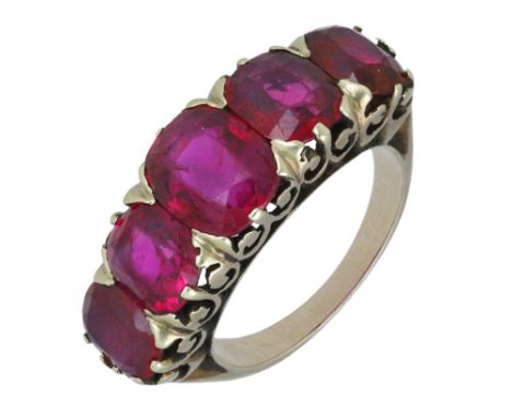 A late 19th century Burmese ruby five stone ring, the graduated cushion-cut rubies claw set to a carved scroll gallery, mount