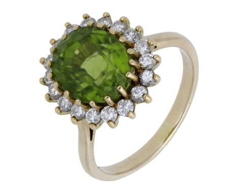 A peridot and diamond cluster ring, the oval mixed-cut peridot claw set within a surround of brilliant-cut diamonds, stamped 