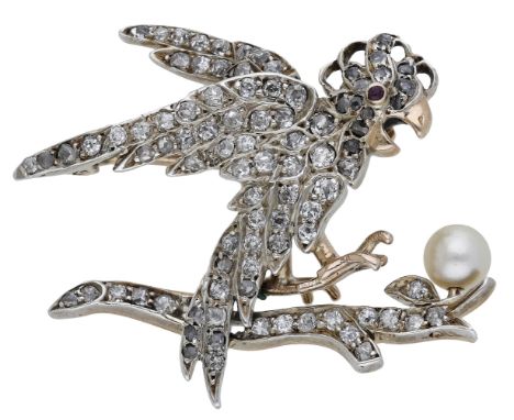 A diamond set cockatoo brooch, the bird hovering above a branch, set throughout with old-cut diamonds, with ruby cabochon eye