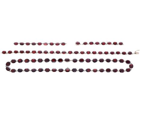 Two garnet rivière necklaces, each composed of oval-cut garnets in closed back pinched collet settings, one stamped ‘9KT’, le