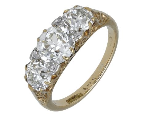 A late 19th century diamond three stone ring, the graduated old brilliant-cut diamonds with similarly-cut diamond highlights 