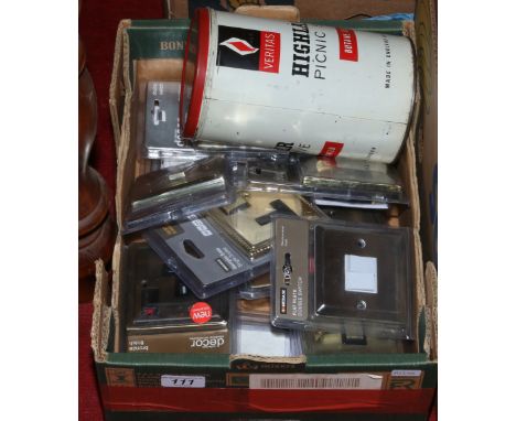 A box of multiple light switches, single switch sockets and a highlander picnic stove.