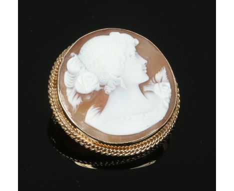 A 9ct gold mounted carved shell cameo of roundel form. Decorated with a portrait of a maiden.