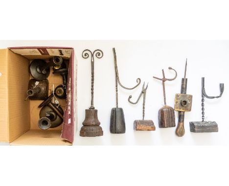 A box containing a variety of 18th century rush holders on wooden bases, cast iron safety lamps, 18th century spiral candlest
