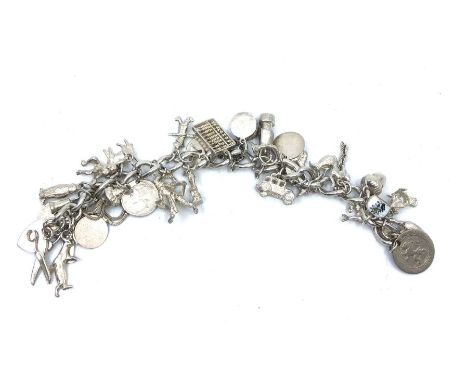 A hallmarked silver chain, with a large number of charms, the vast majority silver including:- a pair of scissors, padlock, h