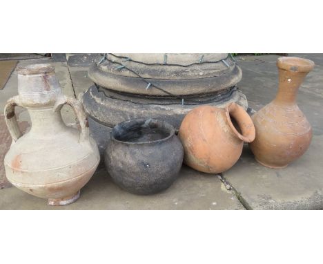 A group of early ceramic wares, possibly Romano-British pieces, including a black-burnished ware urn and three terracotta ves