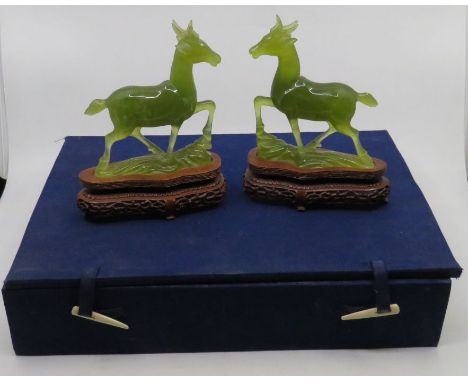 A pair of jade deer on wooden stands in a contemporary blue case. 18 cm tall. (2)Missing ear to one. 