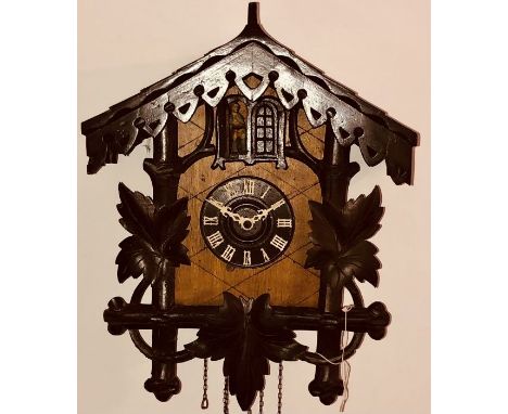 An early 20th century softwood carved quarter chiming with musical box Swiss cuckoo wall clock, weights and pendulum.