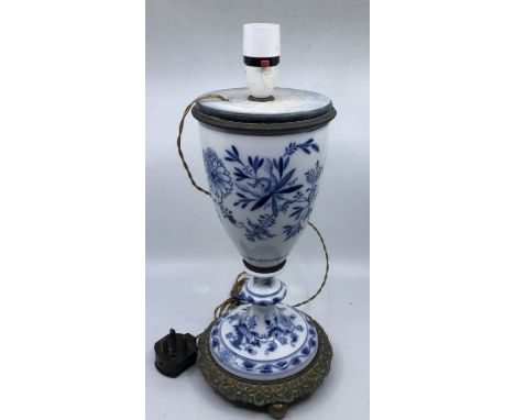A late 19th century blue and white ceramic lamp with brass mounts raised on circular brass feet 40cm high
