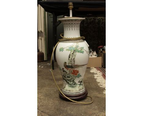 An early to mid 20th century oriental lamp base, on a circular wooden base 61cm high